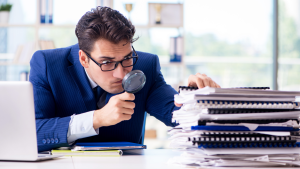 business owner reviewing their books with a magnifying glass