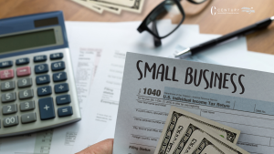 tax return with small business written across the top. desk with adding machine in the backround